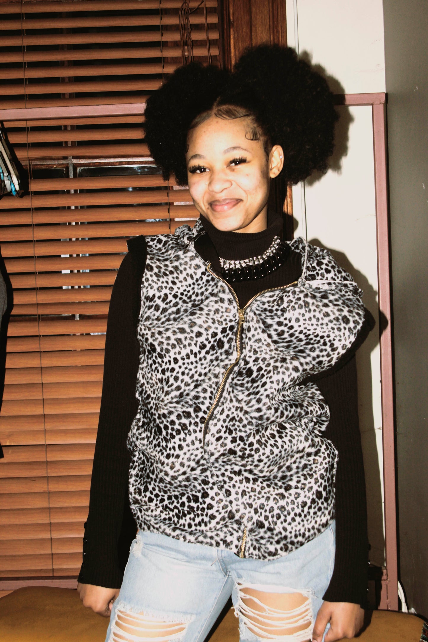 Model wearing a leopard print vest over  in an indoor setting.