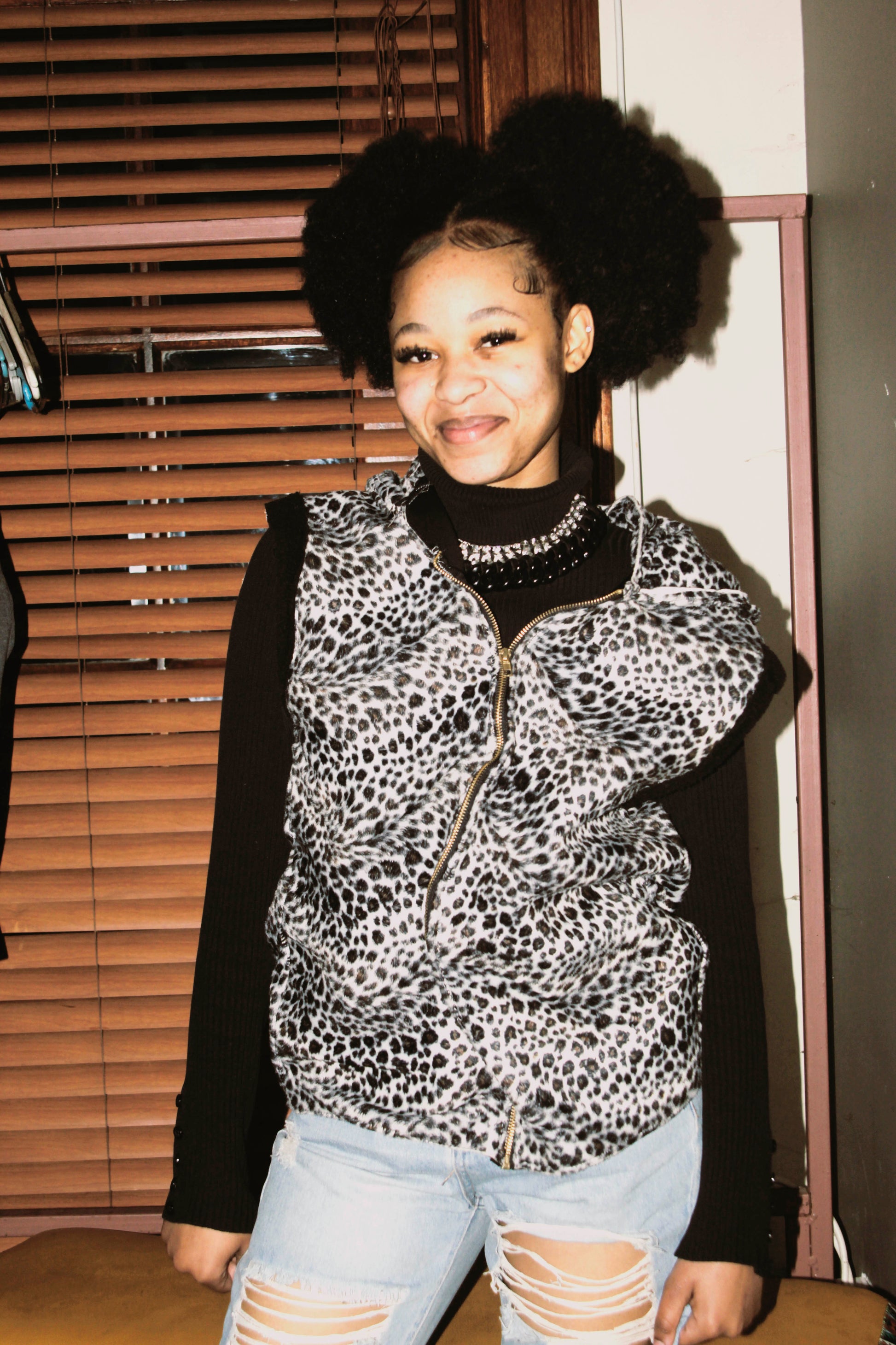 Model wearing a leopard print vest over  in an indoor setting.
